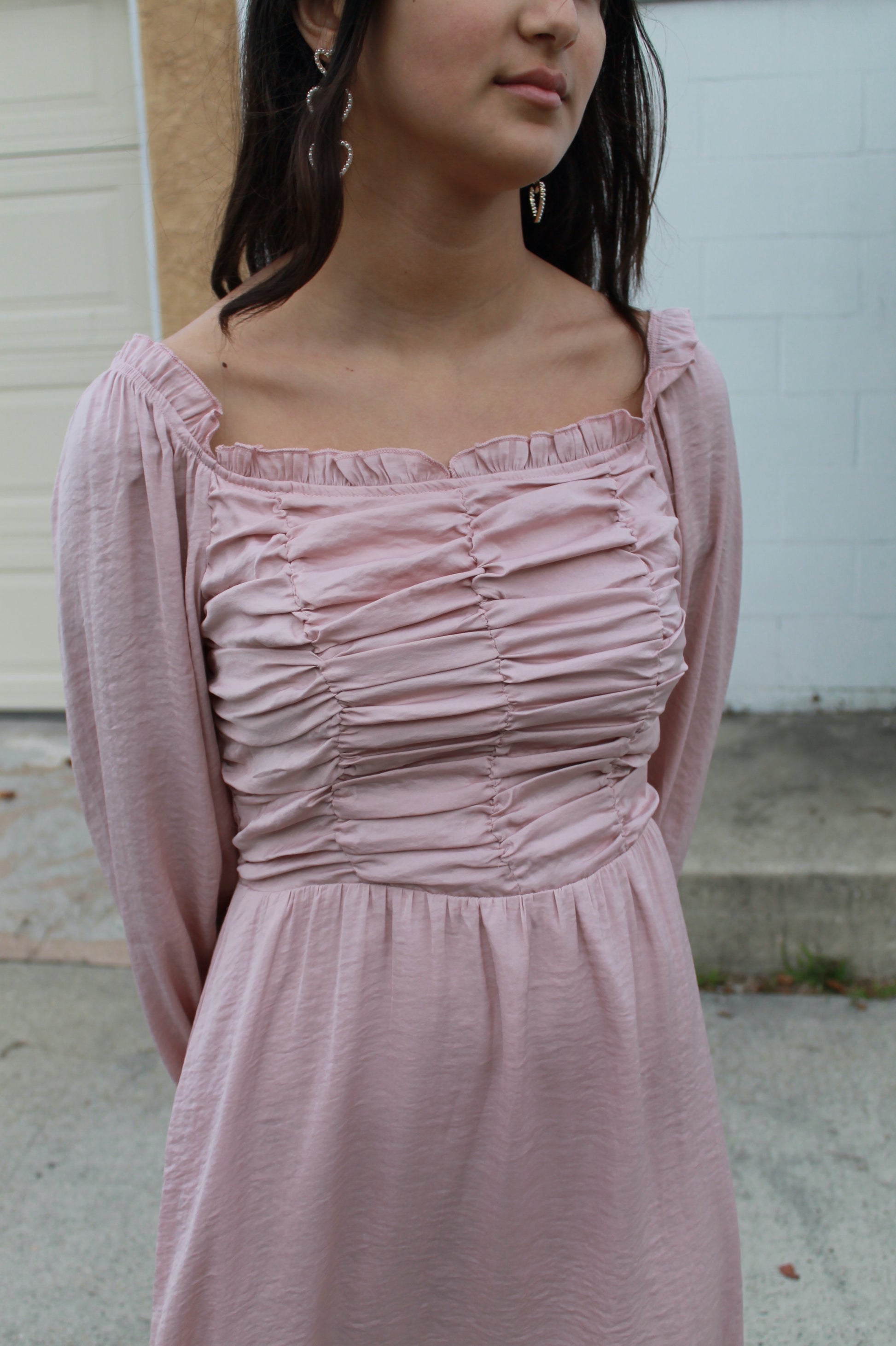 Blush pink ruffled top dress with long sleeves and pockets, knee length.