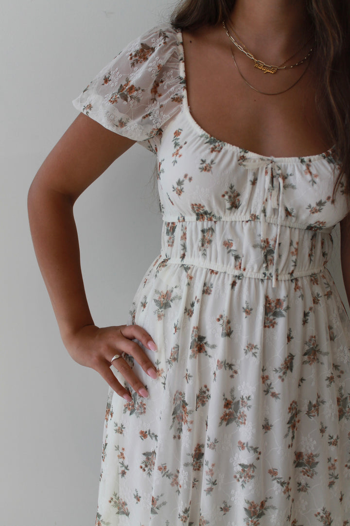 Woman wearing a floral dress with a plain background