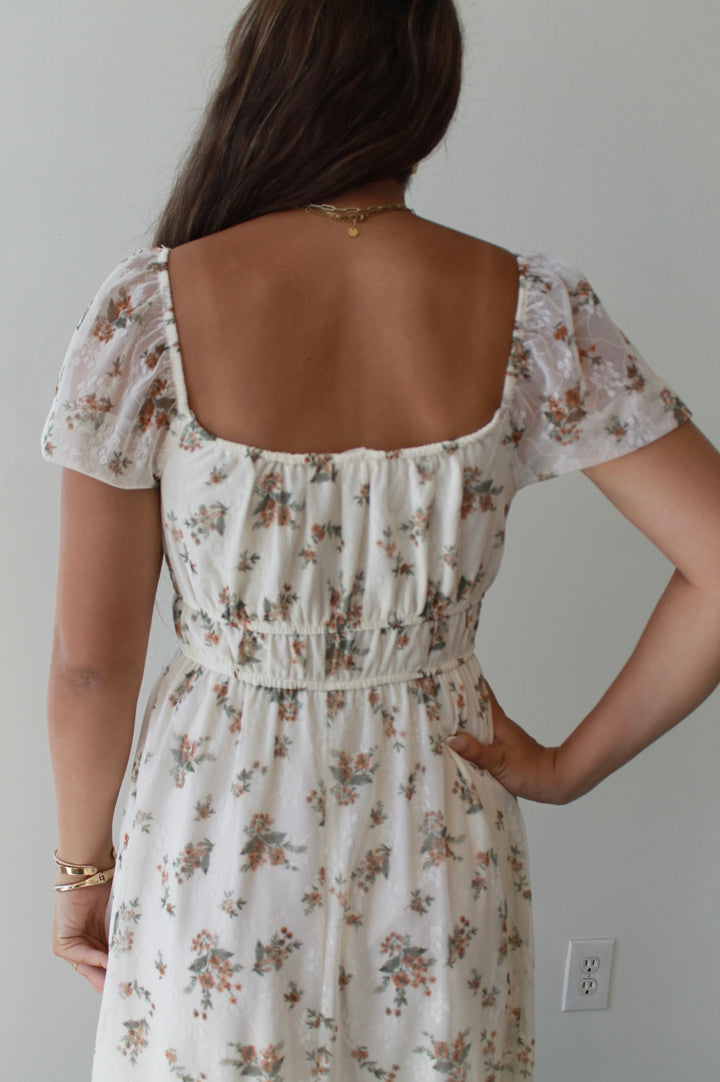 Woman wearing a floral dress with a plain background