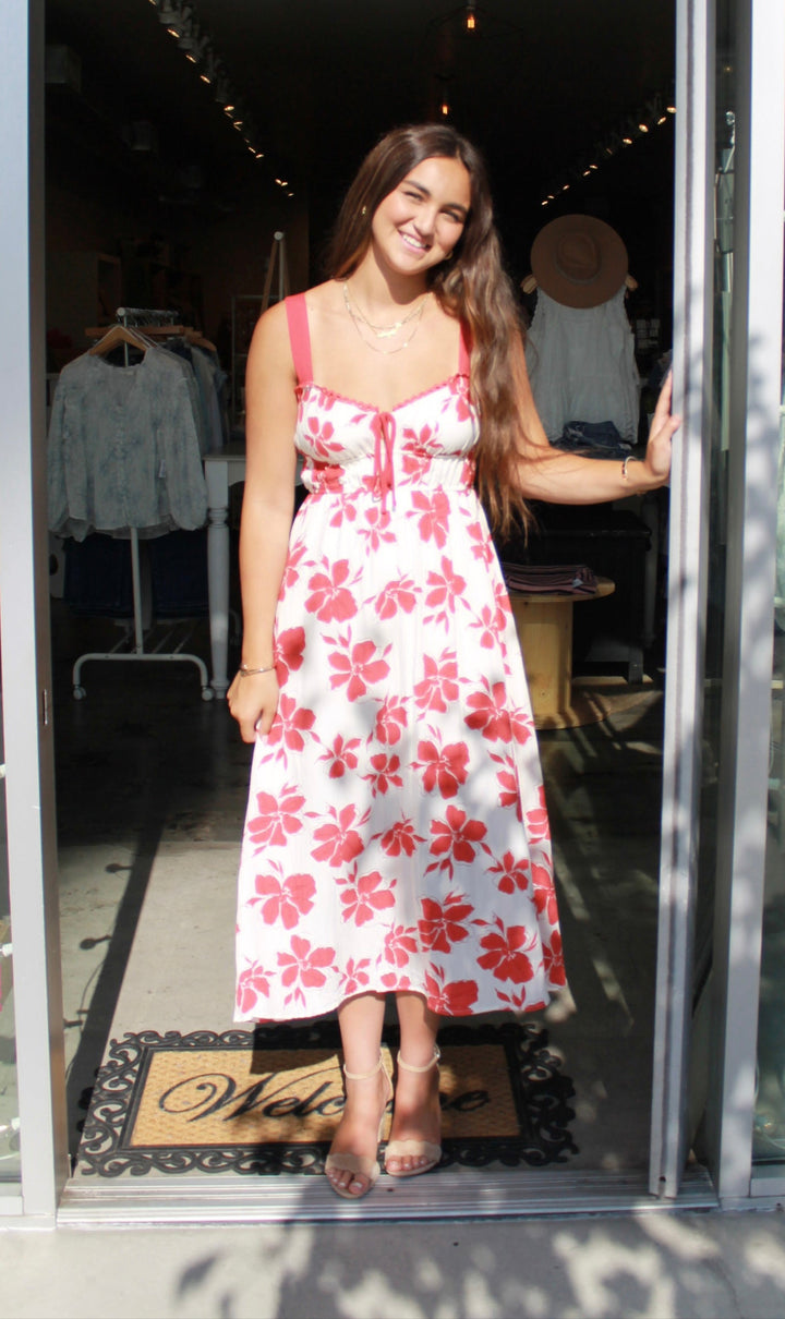 Woman in a floral dress standing in front of a store entrance