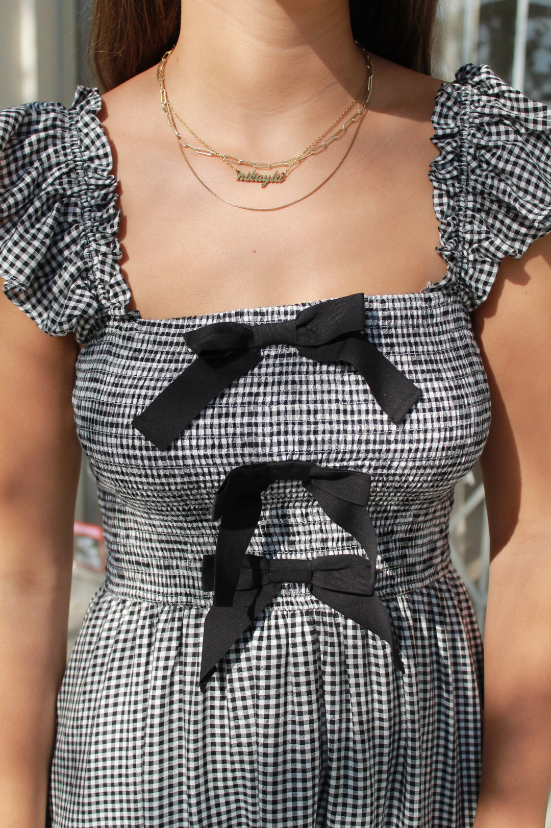 Black and white checkered dress with ruffled sleeves and black bows on a blurred background