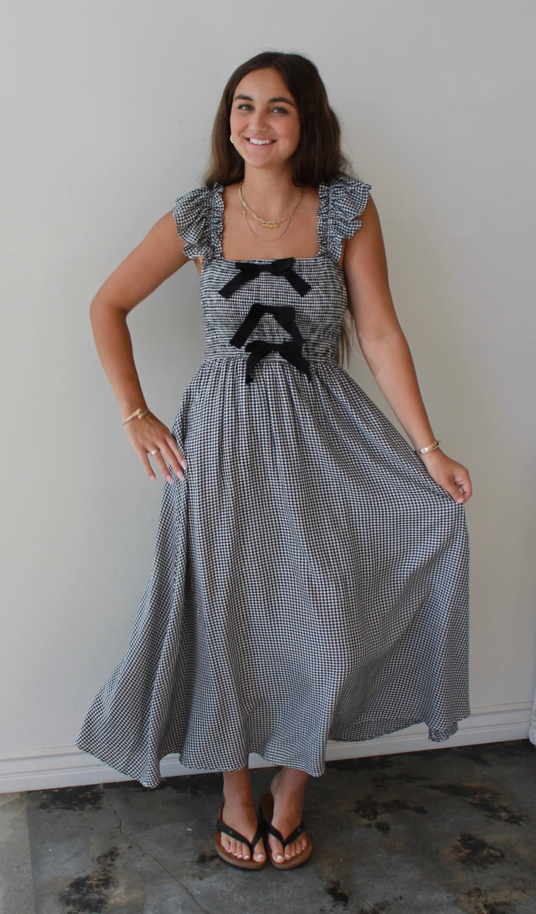 Woman wearing a gray dress with black accents standing indoors.