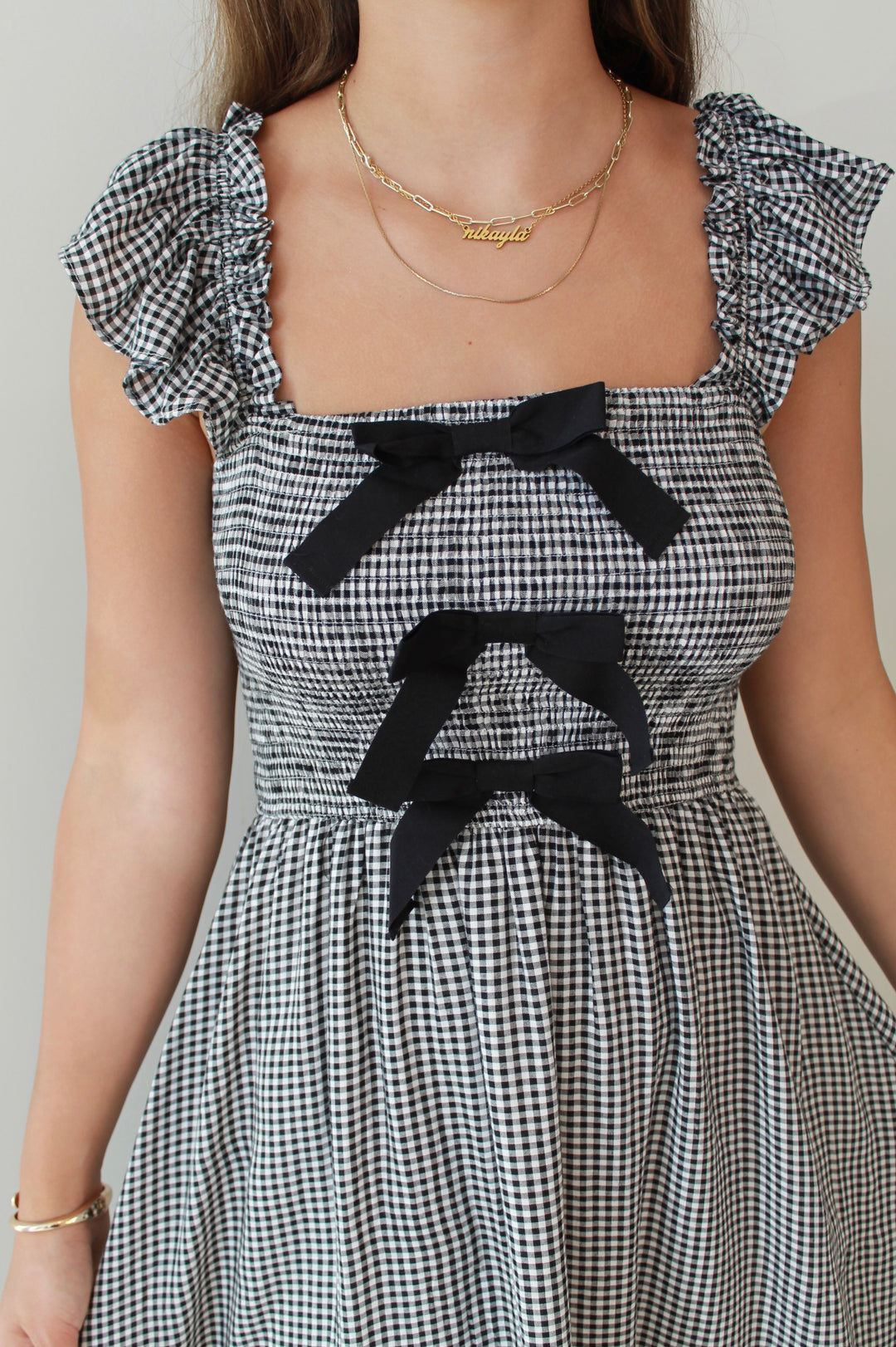 Black and white checkered dress with black bows on a plain background