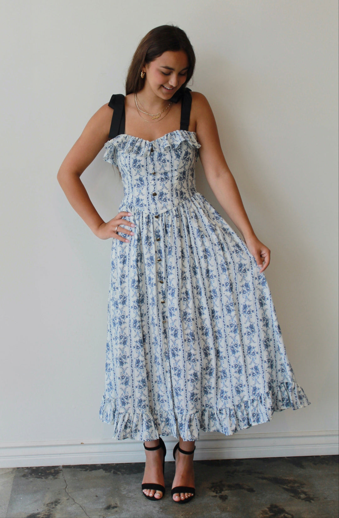Woman wearing a floral dress against a white wall