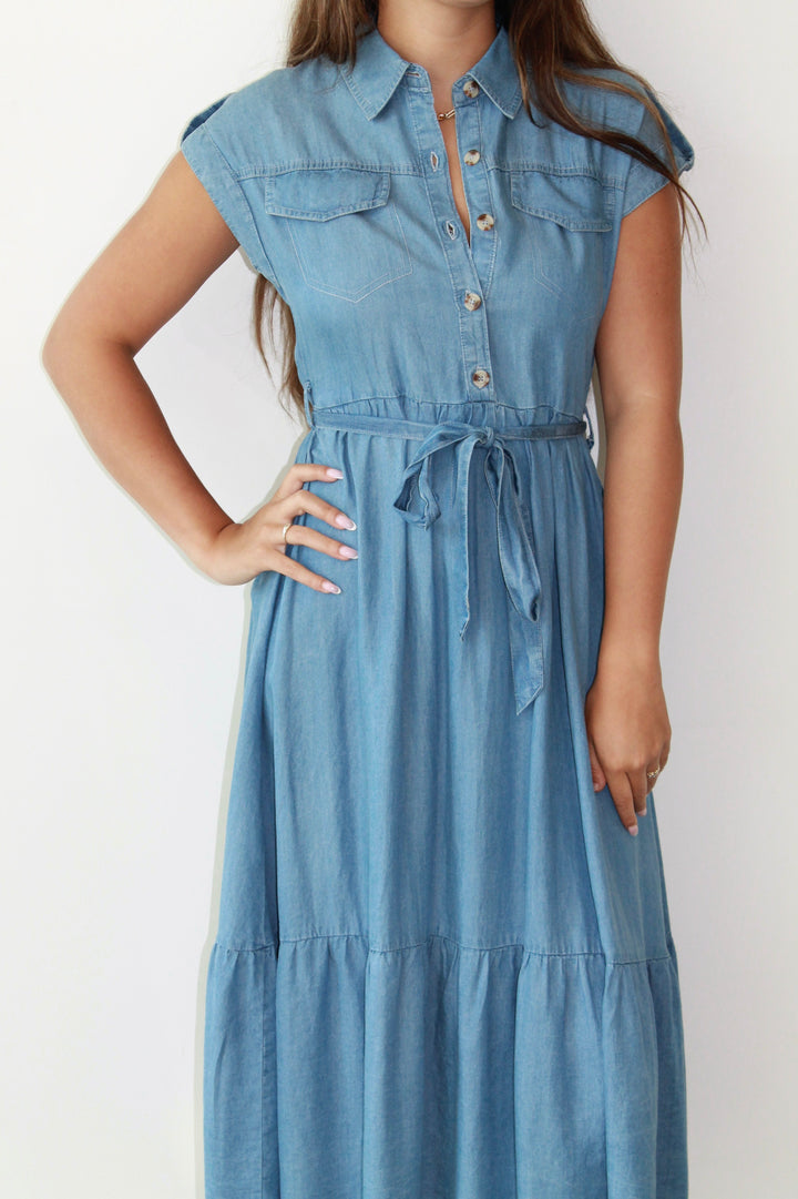 Woman wearing a blue denim dress against a white background