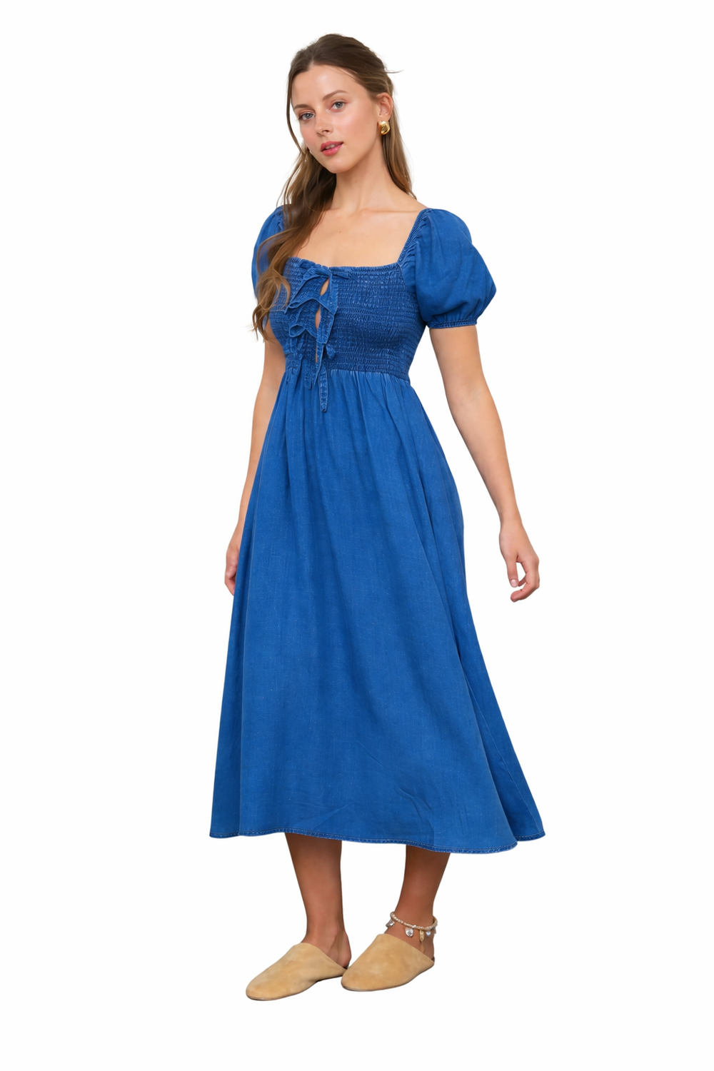 Chambray blue smocked midi dress with bow front detail and puff sleeves shown at angle view on white background