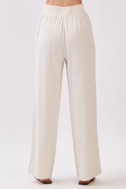 Back view of beige linen wide leg pants with relaxed fit